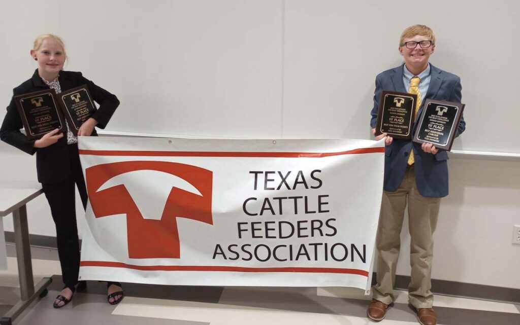 Kennedy and Pierce Wilhelm pose in front of a Texas Cattle Feeders Association banner with awards.