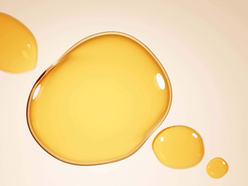 Cottonseed oil drops on a beige background